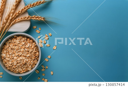 Bowl of Oats With Wheat Stalks on a Blue Background for a Healthy Breakfast Idea. 130857414