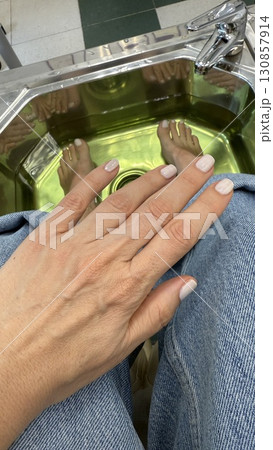 Pedicure and manicure session with female hands and feet submerged in spa water for relaxation Pedicure and manicure session with female hands and feet submerged in spa water for relaxation 130857914