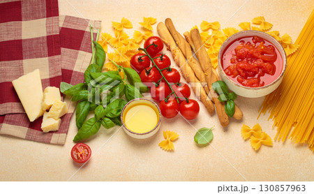 Italian food cuisine background featuring tomato sauce, grissini, pasta, parmesan, fresh basil Italian food cuisine background featuring tomato sauce, grissini, pasta, parmesan, fresh basil 130857963