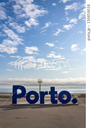 Blue three-dimensional Porto sign on promenade along the coast and beach, Portugal, sunset on sunny summer day Blue three-dimensional Porto sign on promenade along the coast and beach, Portugal, sunset on sunny summer day 130858038