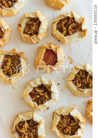 Rustic Fruit Galettes with Honey and Nuts on White Background. Top view 130858110