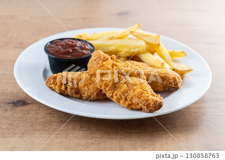 Crispy fried chicken tenders with french fries Crispy fried chicken tenders with french fries 130858763