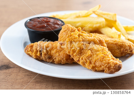Crispy fried chicken tenders with french fries Crispy fried chicken tenders with french fries 130858764