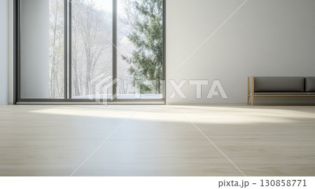 Modern interior with large windows showcasing a serene winter landscape and minimalistic furniture in the foreground 130858771