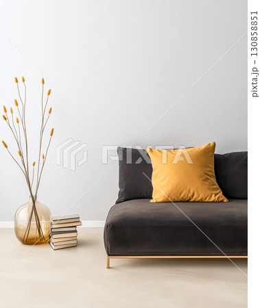 Modern minimalist living room with stylish sofa, decorative vase, and books arranged neatly Modern minimalist living room with stylish sofa, decorative vase, and books arranged neatly 130858851