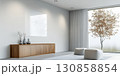 Modern living room with minimalist design featuring natural light and simple furniture in a peaceful setting 130858854
