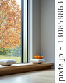 Serene indoor space showcasing minimalist design and nature view with autumn colors in the background 130858863
