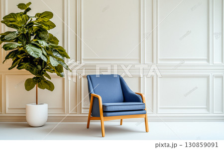 Cozy blue chair next to a green plant in a minimalist modern interior design setting 130859091