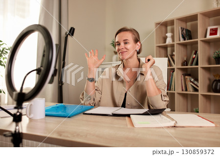 Professional woman hosting an engaging virtual meeting at home office setup 130859372