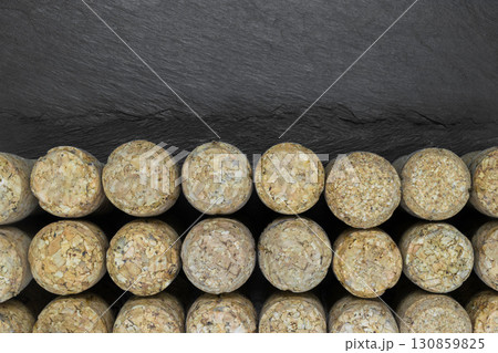 Background of champagne corks on black stone background with copy space 130859825