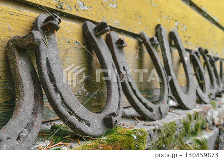 Background surface of very old and rusty horseshoes placed near the wall 130859873