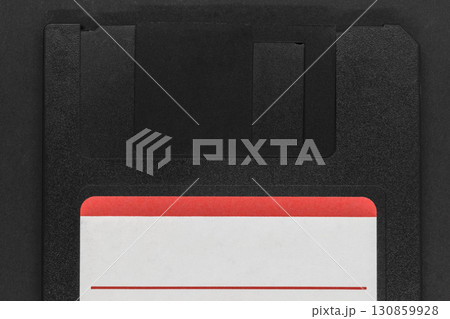 Black floppy disk on black background 130859928