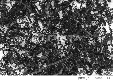 Bunch of shredder black curly carton paper strips background placed on white background Bunch of shredder black curly carton paper strips background placed on white background 130860043