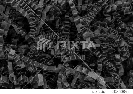 Close up view of bunch shredder black curly carton paper strips background surface 130860063