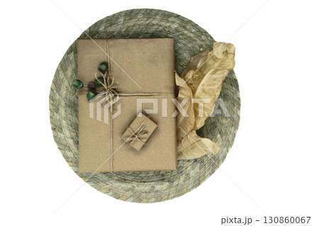 Composition of gift boxes wrapped in beige paper and bundled with ribbons. Decorated with young oak acorns and dry leaves Composition of gift boxes wrapped in beige paper and bundled with ribbons. Decorated with young oak acorns and dry leaves 130860067
