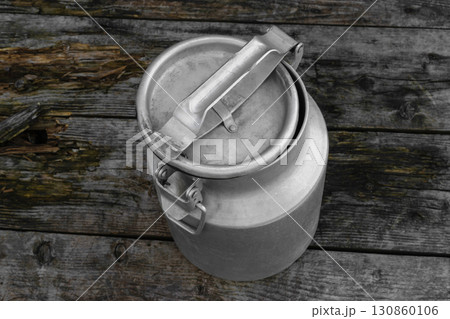 Drying Washed Metal Milk Canisters, Churns in the Countryside on the wooden background Drying Washed Metal Milk Canisters, Churns in the Countryside on the wooden background 130860106