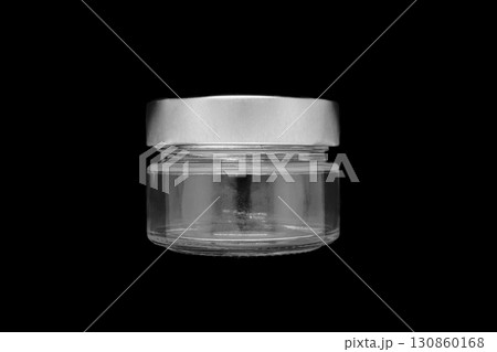 Glass jar with metal lid on it isolated on black background surface 130860168