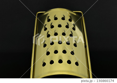 Golden grater on black background 130860174