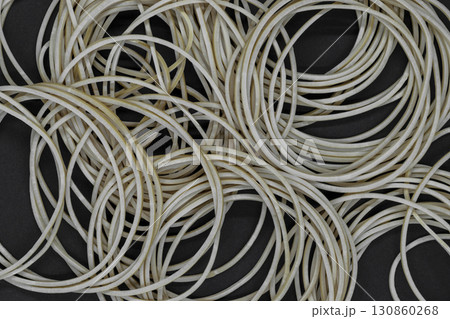 Many brown rubber rings on black background surface Many brown rubber rings on black background surface 130860268