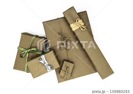 Mix of various sizes gift boxes wrapped in beige paper and bundled with different ribbons on white background Mix of various sizes gift boxes wrapped in beige paper and bundled with different ribbons on white background 130860283