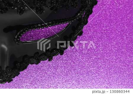 Part of black carnival mask on shining purple color background 130860344