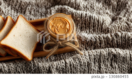 Jar of Peanut Butter with Bread on Cozy Knitted Surface 130860455