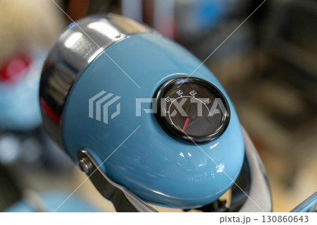 Close-up of speedometer on light blue vintage scooter headlight Close-up of speedometer on light blue vintage scooter headlight 130860643