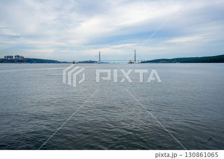Vibrant waterscape view of Vladivostok highlighting nature and modern bridges Vibrant waterscape view of Vladivostok highlighting nature and modern bridges 130861065