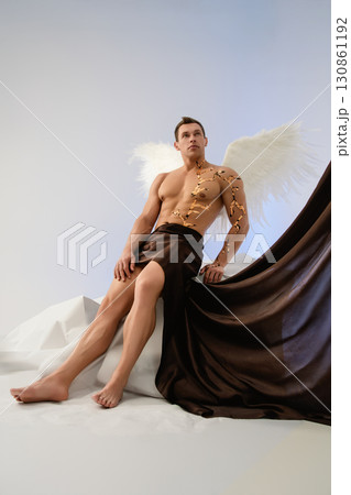 Dramatic portrayal of a man with angel wings in an artistic setting 130861192