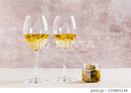 White wine infused with jalapeno slices in glasses on the table White wine infused with jalapeno slices in glasses on the table 130861246