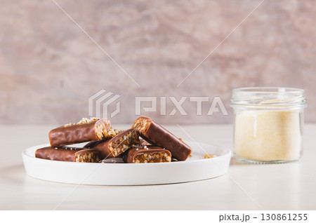 Protein bars with nuts on plate and protein powder in jar on table Protein bars with nuts on plate and protein powder in jar on table 130861255