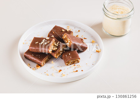 Chocolate nut protein bars on a plate on a table Chocolate nut protein bars on a plate on a table 130861256