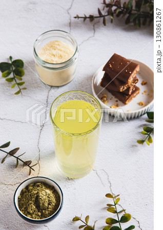 Matcha tea with protein powder in a glass and bars on the table vertical view 130861267
