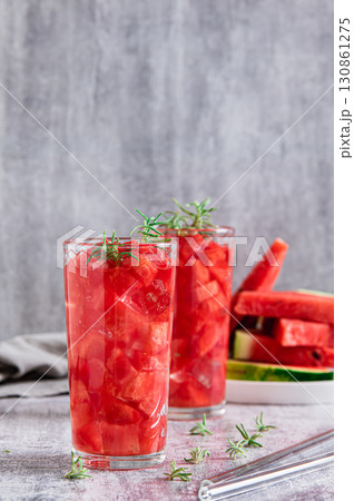Detox summer drink with watermelon and rosemary in glasses on table vertical view Detox summer drink with watermelon and rosemary in glasses on table vertical view 130861275