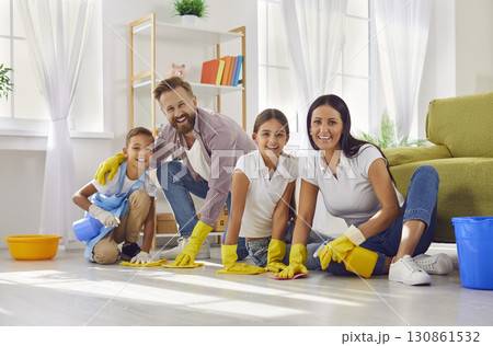 Happy mother, father and children cleaning up at home and washing floor all together Happy mother, father and children cleaning up at home and washing floor all together 130861532