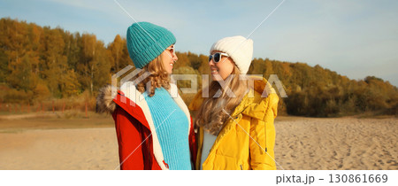 Happy young two women friends on sunny beach, stylish girlfriends smiles together on sea coast 130861669
