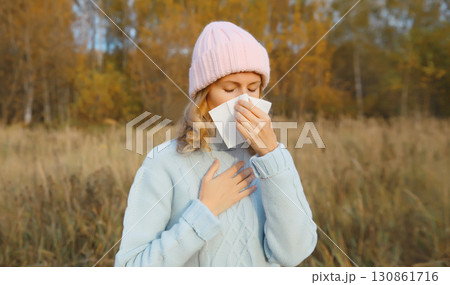 Sick woman sneezing blow nose using tissue, unhealthy suffering girl feels unwell outdoors 130861716