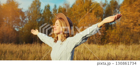 Happy young smiling woman in autumn park, joyful girl enjoying warm sunny weather, fall season Happy young smiling woman in autumn park, joyful girl enjoying warm sunny weather, fall season 130861734