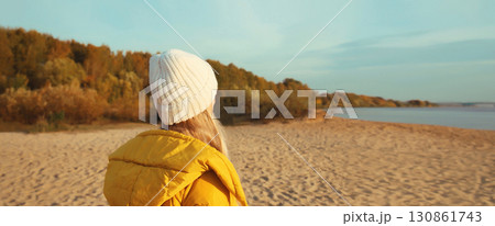 traveler woman looking away on sunny beach, enjoying landscape on sea coast, nature background traveler woman looking away on sunny beach, enjoying landscape on sea coast, nature background 130861743