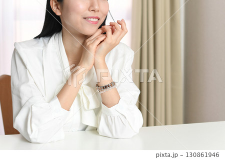 明るい室内で座る笑顔の若いアジア人女性 明るい室内で座る笑顔の若いアジア人女性 130861946