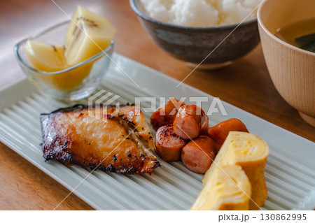 焼き魚と卵焼き、ソーセージ、キウイ、ご飯と味噌汁の和朝食 130862995