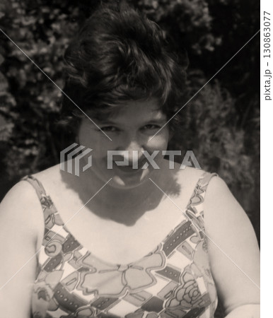 Vintage portrait of a pretty middle-aged woman. Beautiful woman smiles mysteriously. Retro photo 1982 130863077