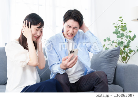 スマートフォンを使う男女 パニック 混乱 スマートフォンを使う男女 パニック 混乱 130863097
