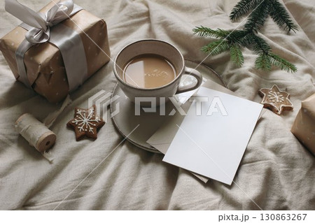 Winter still life. Cup of coffee, star gingerbread cookies. Linen table cloth. Gift box with ribbon, fir tree branch. Christmas breakfast, stationery. Blank greeting card, invitation mockup. Flatlay Winter still life. Cup of coffee, star gingerbread cookies. Linen table cloth. Gift box with ribbon, fir tree branch. Christmas breakfast, stationery. Blank greeting card, invitation mockup. Flatlay 130863267