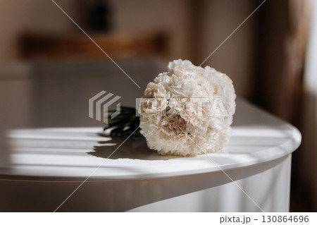 Elegant bridal bouquet on white piano in soft morning light Elegant bridal bouquet on white piano in soft morning light 130864696