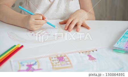 Close-up of a child's hands coloring a drawing with bright pencils. Young girl engaging in colorful artistic drawing and coloring activity using pencils. Enhancing creativity. Imagination Close-up of a child's hands coloring a drawing with bright pencils. Young girl engaging in colorful artistic drawing and coloring activity using pencils. Enhancing creativity. Imagination 130864891