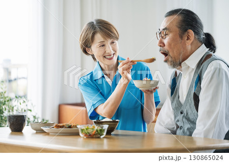 シニア男性に食事介助をする女性介護士 130865024