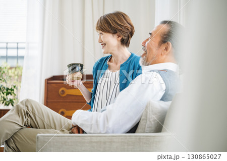 家のソファーで楽しくTVを見るシニア夫婦 130865027