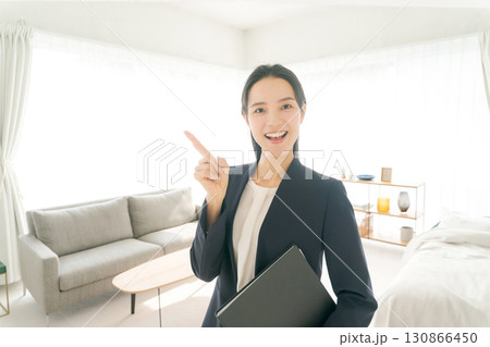 モデルルームの案内をするスーツの女性 130866450