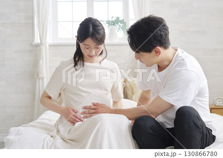 妊娠している妻のお腹を触る夫 130866780